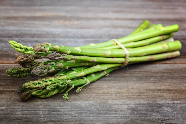 Kuşkonmaz yeşil bir ahşap arka plan üzerinde taze.