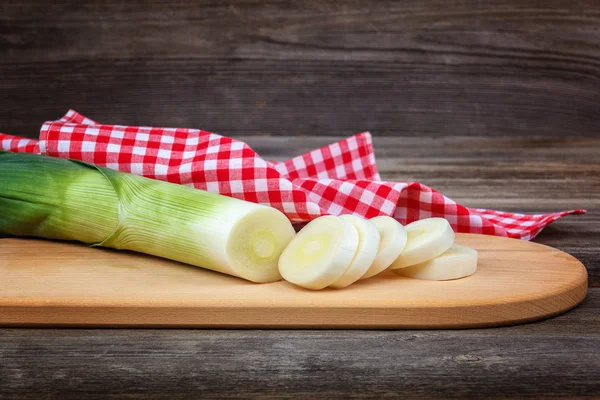Ahşap bir arka plan üzerinde taze yeşil soğan.