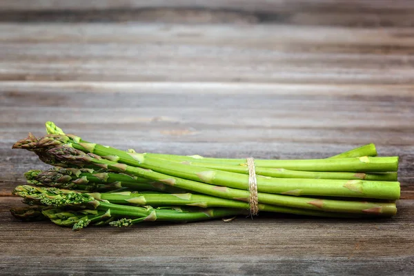 Kuşkonmaz yeşil bir ahşap arka plan üzerinde taze.