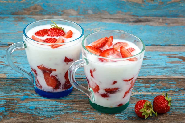 Ahşap arka plan üzerinde bir kasede ekşi kremalı taze çilek.