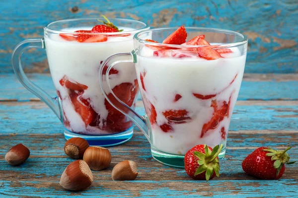 Ahşap arka plan üzerinde bir kasede ekşi kremalı taze çilek.