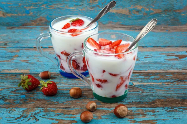 Ahşap arka plan üzerinde bir kasede ekşi kremalı taze çilek.