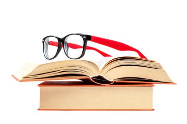 Beyaz arkaplanda izole bir kitap yığını üzerinde açık kitap ve gözlük.
