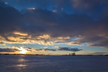 Kış karla kaplı alan ve mavi gökyüzü bulutlu.