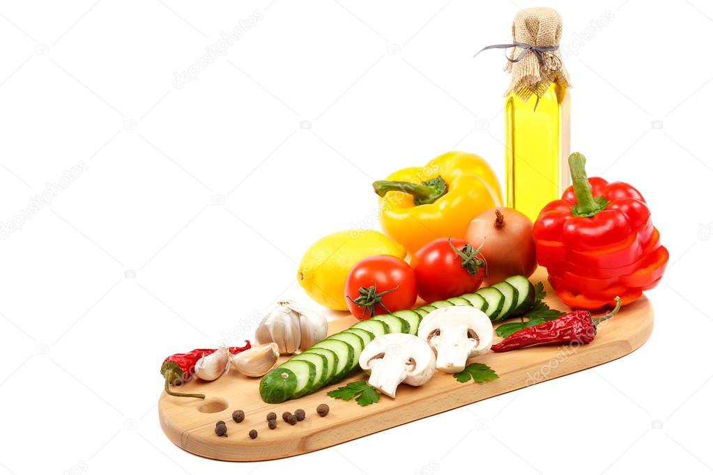 Slices of fresh vegetables on a cutting wooden board isolated on white background.