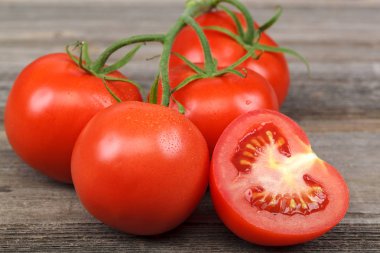 Bir taze kırmızı domatese dalı ahşap arka plan.