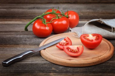 Kesme tahtasında taze sebzeler ve tahta bir arka planda bıçak..