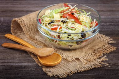 Taze sebze ve ahşap arka plan üzerinde yemekleri sebze salatası.