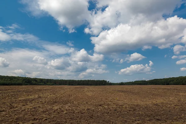 Terra Campo Arato Contro Cielo Blu Con Nuvole — Foto Stock