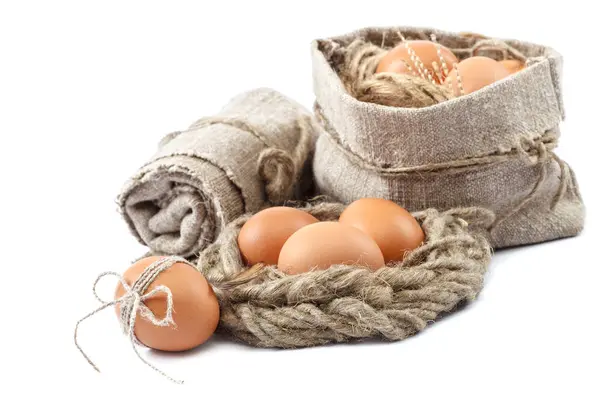 Куриные яйца на холсте на белом фоне — стоковое фото