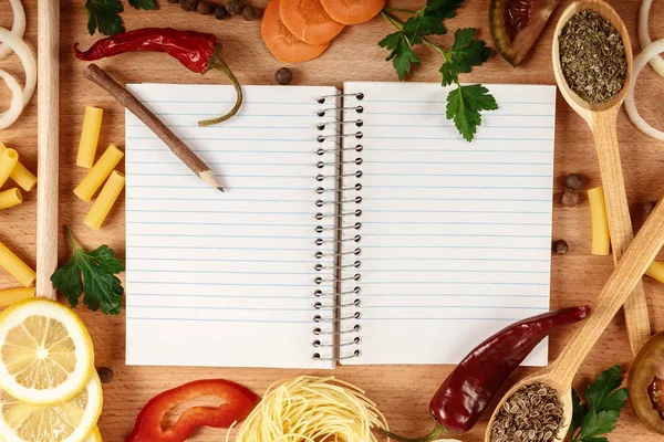 Skivade grönsaker och frukter, kryddor och en kokbok — Stockfoto