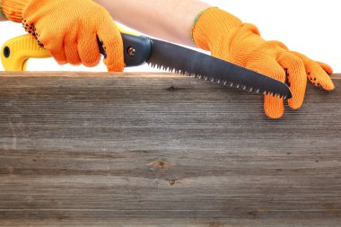 Folding garden saw in hand with a glove clipart