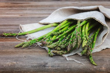 Kuşkonmaz yeşil bir ahşap arka plan üzerinde taze