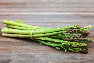 Kuşkonmaz yeşil bir ahşap arka plan üzerinde taze