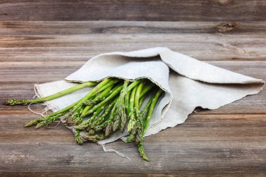 Kuşkonmaz yeşil bir ahşap arka plan üzerinde taze