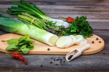 Kuşkonmaz, soğan ve maydanoz taze bir tahta üzerinde yeşil