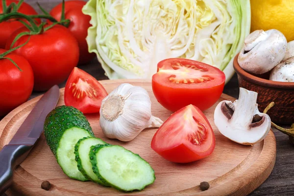 Friss zöldségek késsel a vágódeszkán — Stock Fotó