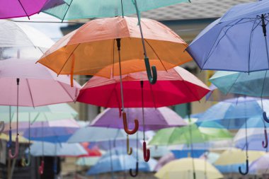 Bir caddede renkli şemsiyeler 