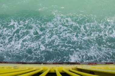 Blue sea with prop wash wake by Cargo ship