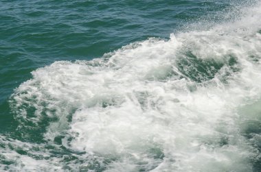 Tekne teknenin yanındaki suda uyanıyor.