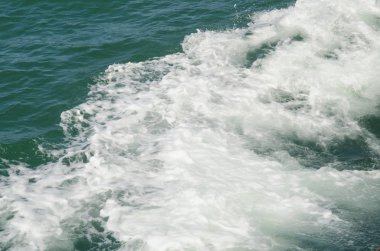 Tekne teknenin yanındaki suda uyanıyor.