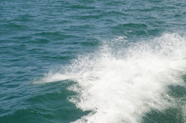 Tekne teknenin yanındaki suda uyanıyor.