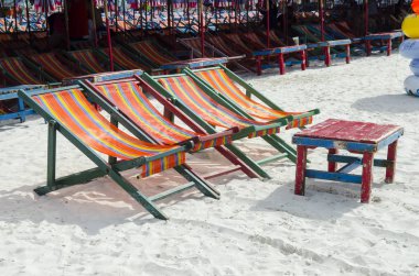 empty beach chairs on sand