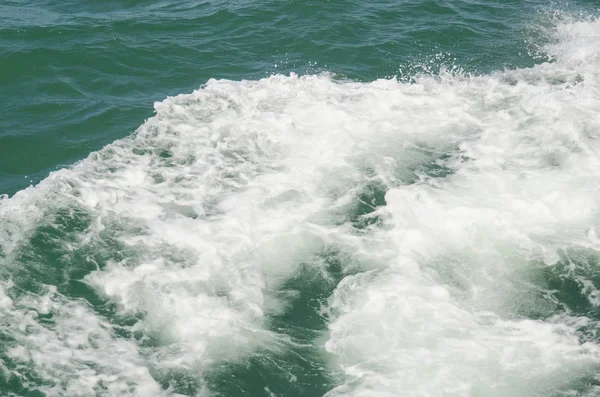 Tekne teknenin yanındaki suda uyanıyor.