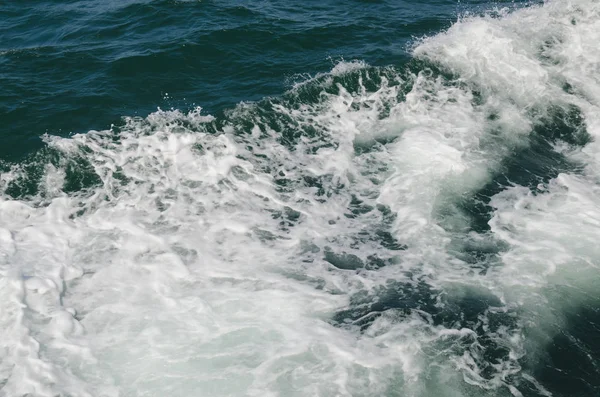 Tekne teknenin yanındaki suda uyanıyor.