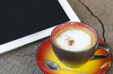 Dijital tablet ve kahve fincanı ahşap tablo