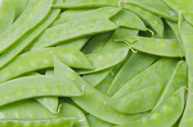 Beyaz arkaplanda yeşil bezelye kabukları izole