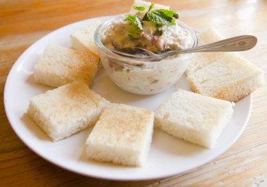 Tahtada domatesli, marullu ve mayonezli ton balıklı sandviç.