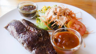 Baharatlı hindi soslu, soğan ve mantarlı ızgara devekuşu bifteği..