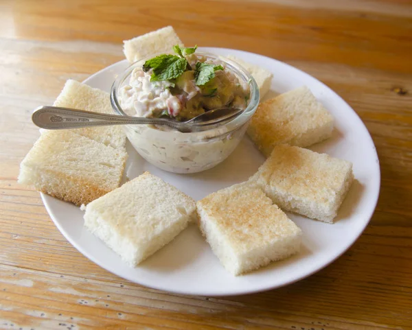 Tahtada domatesli, marullu ve mayonezli ton balıklı sandviç.