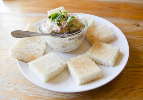 Tahtada domatesli, marullu ve mayonezli ton balıklı sandviç.