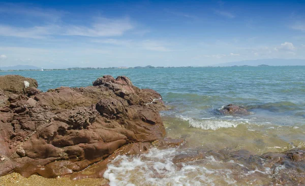 sea beach with blue sky and rocky shore