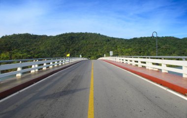 Asfalt yol ve mavi gökyüzü ile dağ