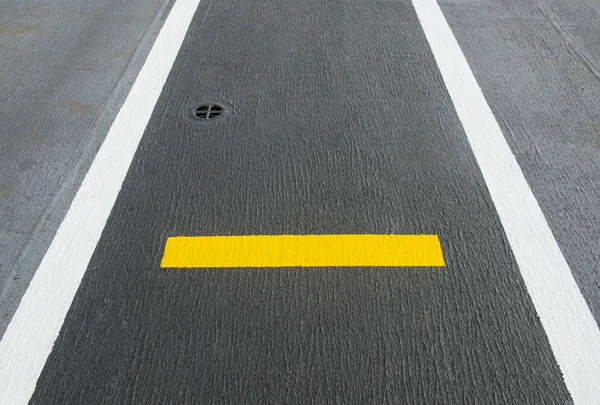 A picture of black and yellow airport markings on concrete