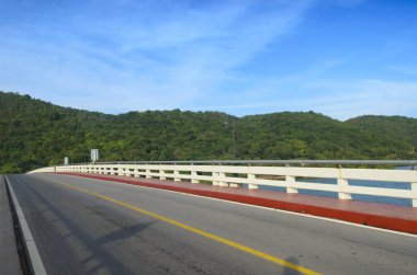 Asfalt yol ve mavi gökyüzü ile dağ