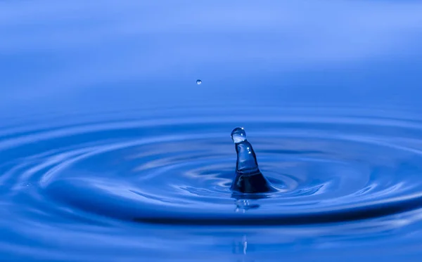 Крапля Води Бризкає Синьому Рідкому Фоні — стокове фото