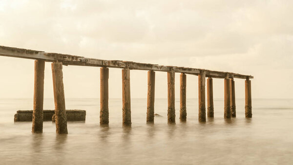 Bridge on beach in sunrise and sea wave in Rayong, Thailand