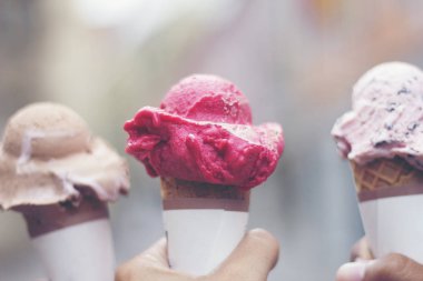 Ellerinde erimiş dondurmalı waffle külahı tutan bir kadın.