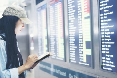 havaalanında akıllı telefon kullanarak güzel seyahat kadın. Genç Asyalı gezgin terminal veya tren istasyonunda cep telefonu uygulaması ile biniş zamanı kontrol. Tatil konseptinde turist.