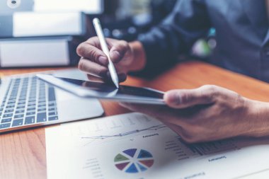 Çekici Genç Ofis işadamı Ona Masa Yaslanmış iken İş Kağıtları Üzerinde Çalışıyor.