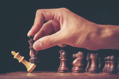 eski bir ahşap masa üzerinde satranç figürleri ile clasped elleri planlama stratejisi ile bir işadamının vintage tarzı görüntü.