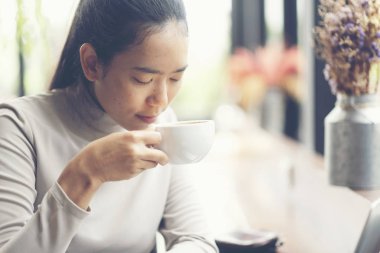 Sabah kahvesi. Kadın bir kahve fincanı tutar, iş konsepti