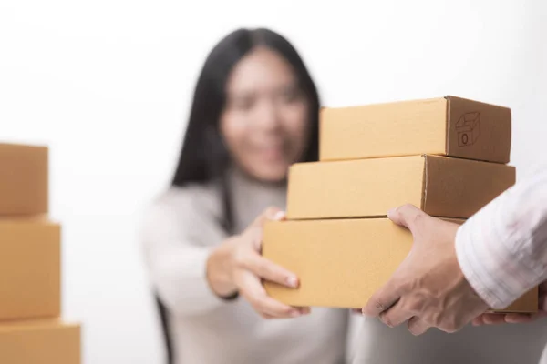 Happy businesswoman receiving a package sitting on a desk at office