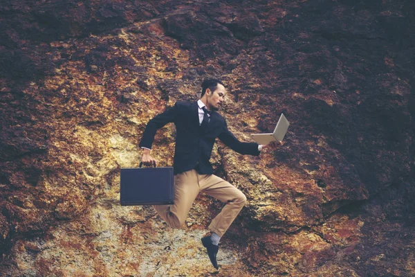 Businessman in suit running in the air as symbol of active life position. Skyscape with sunlight and nature view on background