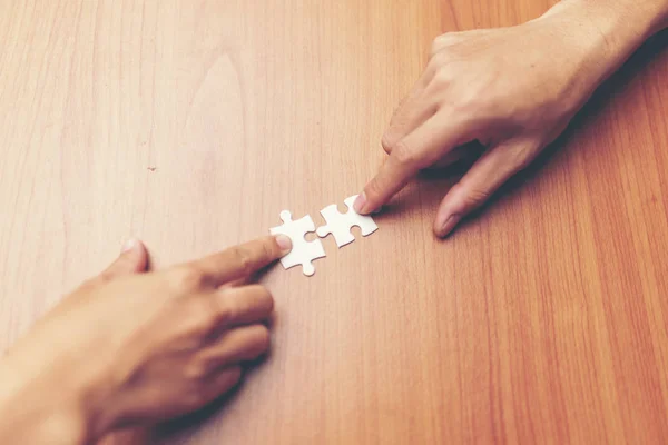 Man hands connecting couple puzzle piece in office. Business solutions, target, successful, goals and strategy concepts