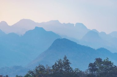 Dağların siluetleriyle turuncu ve sarı günbatımı. Gradyan vi
